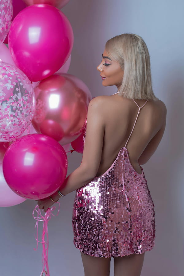 Chica rubia con vestido rosado escarchado para cumpleaños